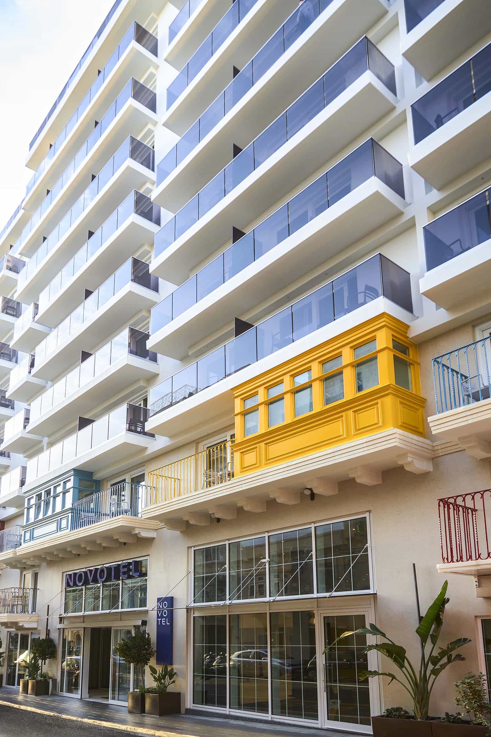 Hotel facade with a traditional yellow Maltese balcony